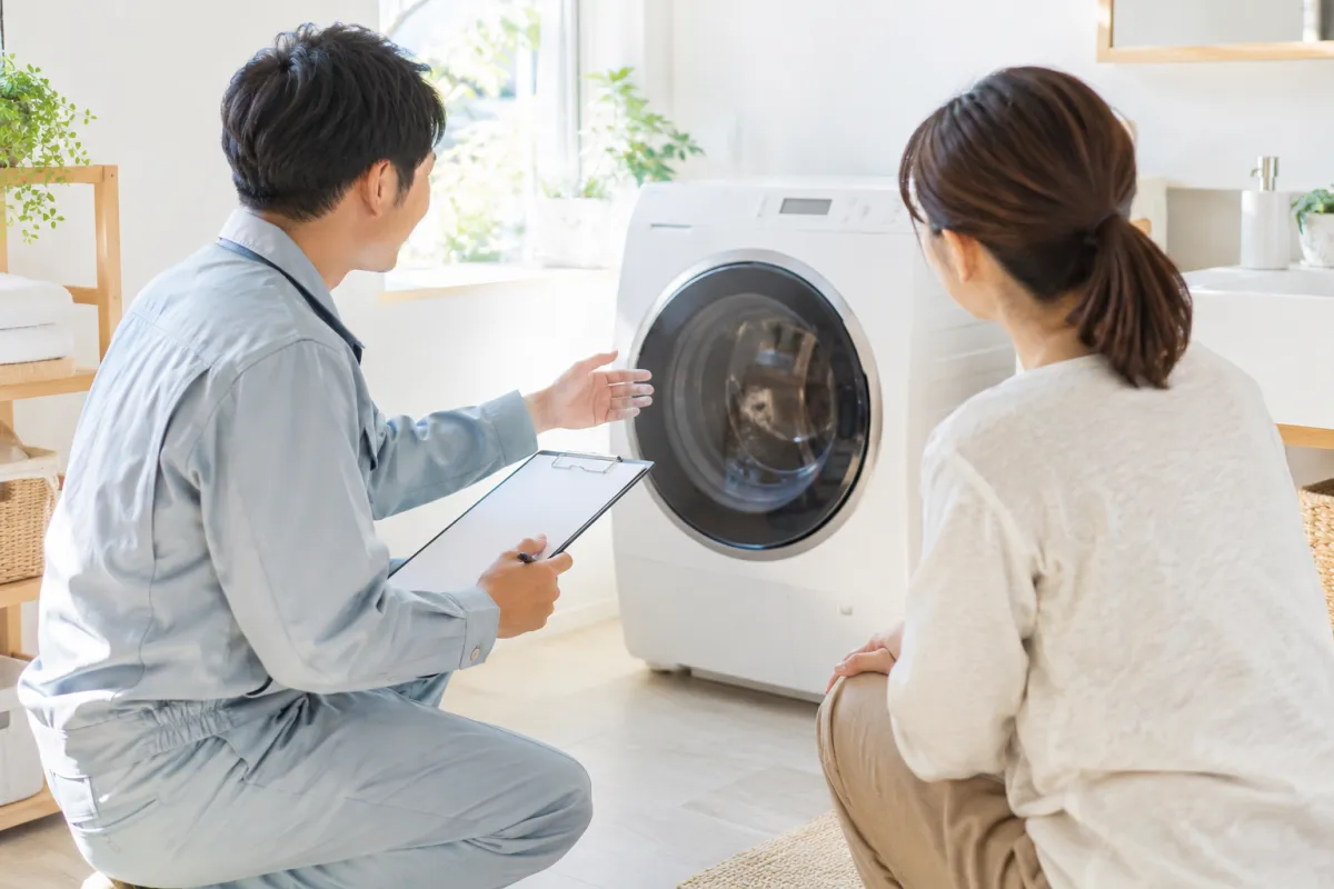 洗濯機を前に症状を相談する場面