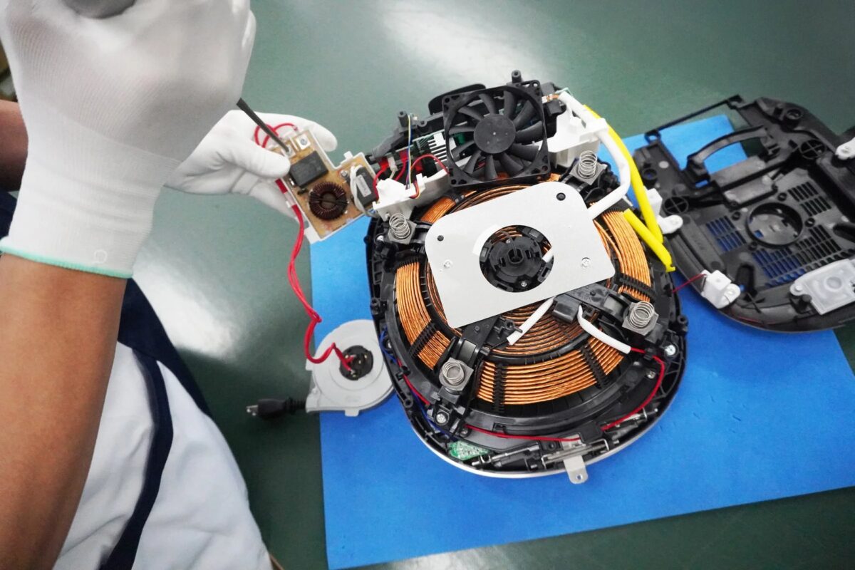 電子機器の内部部品を組み立てる作業員