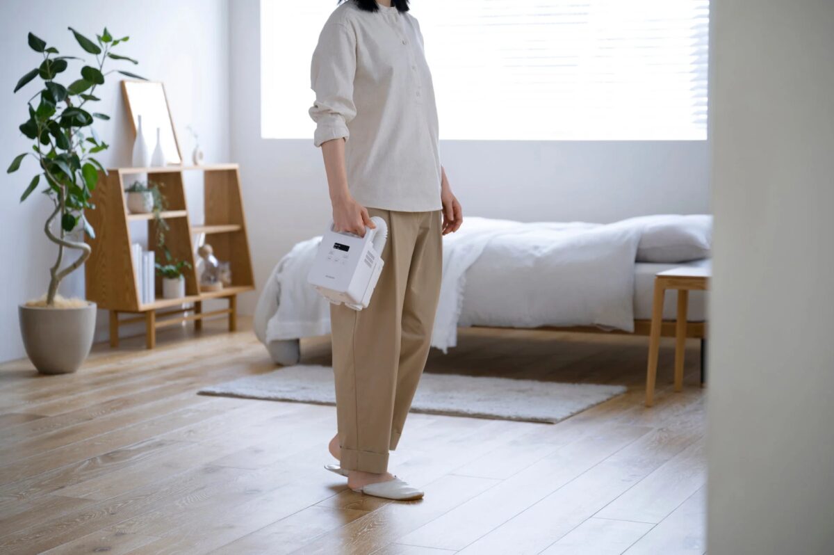 女性がふとん乾燥機を持っている様子
