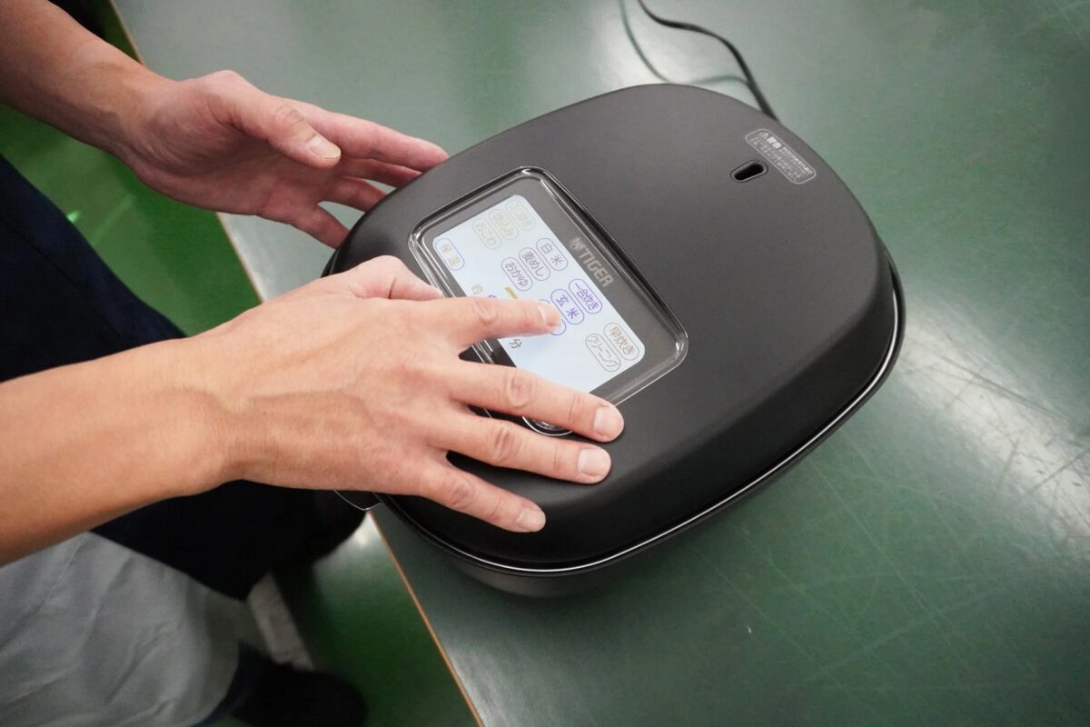 TIGER製炊飯器のタッチパネルを操作する様子