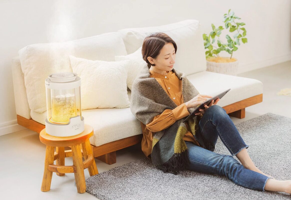 リビングでくつろぐ女性と加湿器